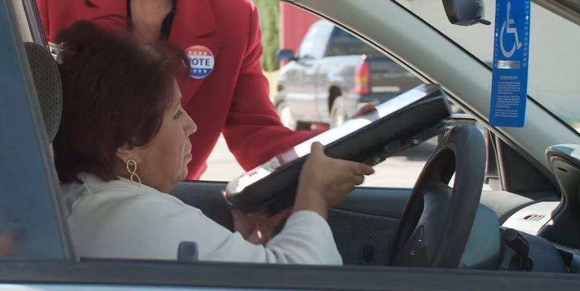 woman in car curbside voting