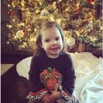 photo of little Haylee in front of Christmas tree