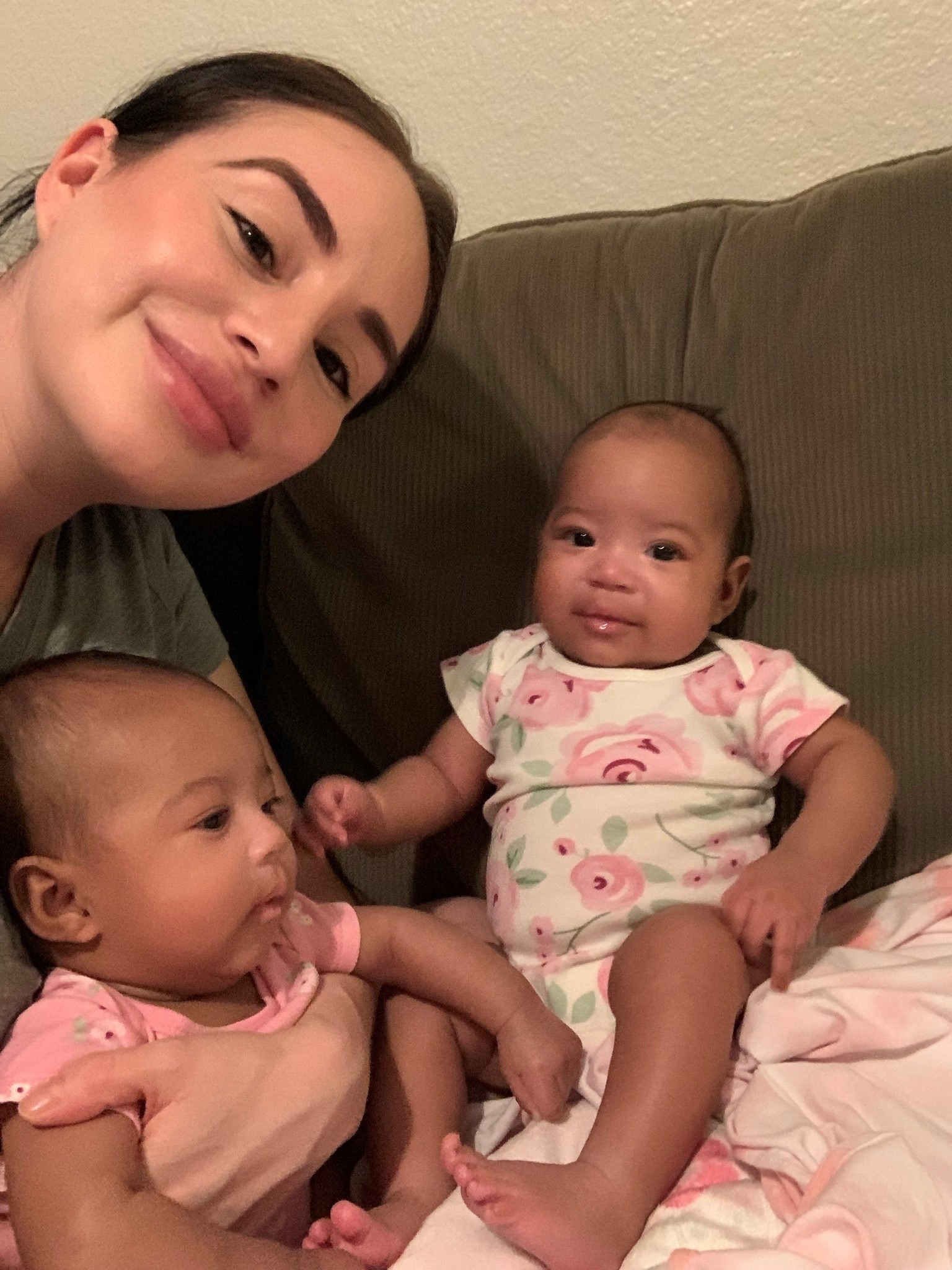 Woman with her twin babies smiling at the camera