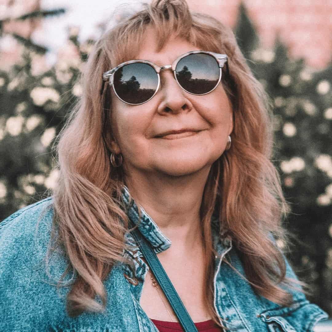 Woman wearing sunglasses smiling.