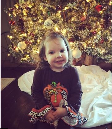 photo of little Haylee in front of Christmas tree