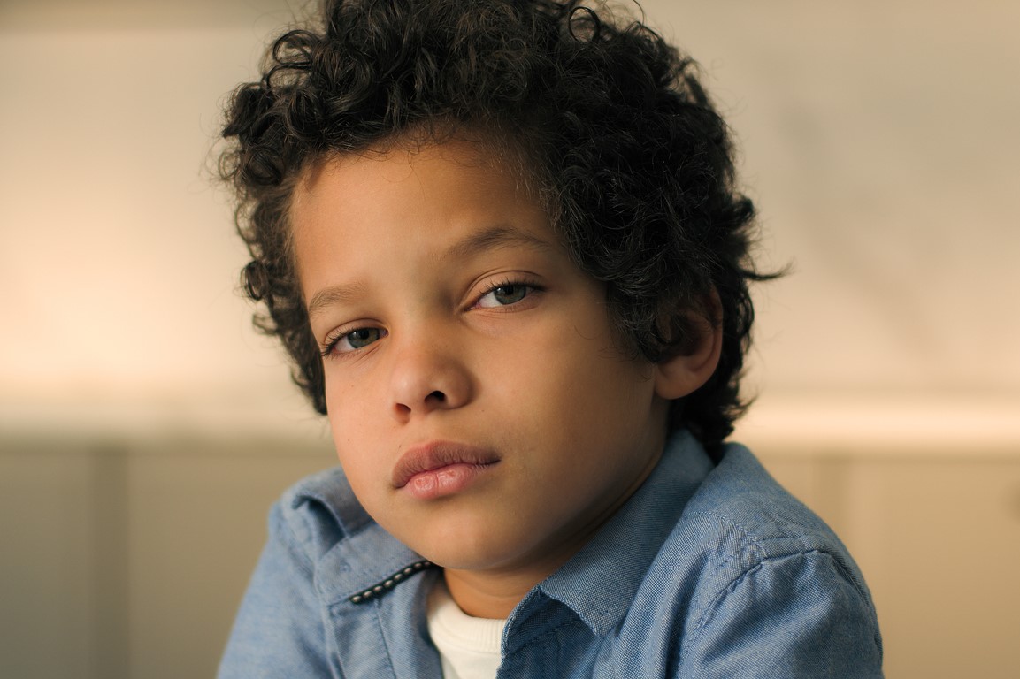 A young boy looks despondent.