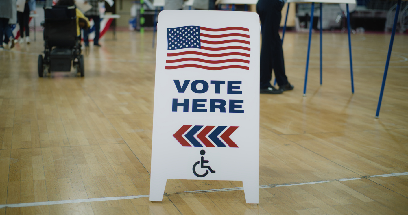 A vote here sign inside a gym.