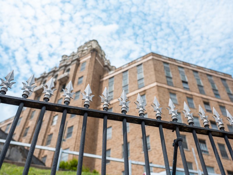 Looking up through a spiked fence at a large institution.