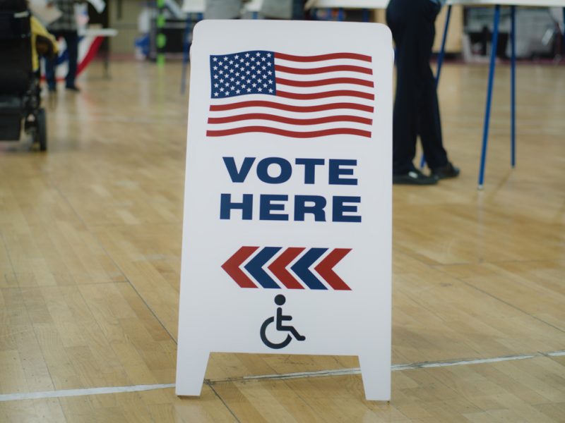 A vote here sign inside a gym.