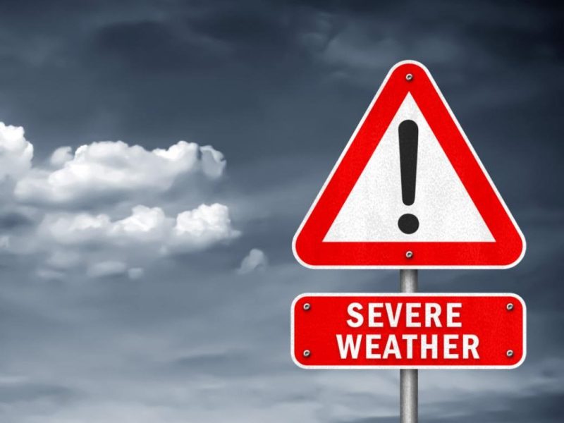 A street sign that's a red triangle with an exclamation point in it and the words severe weather. A cloud sky is in the background.